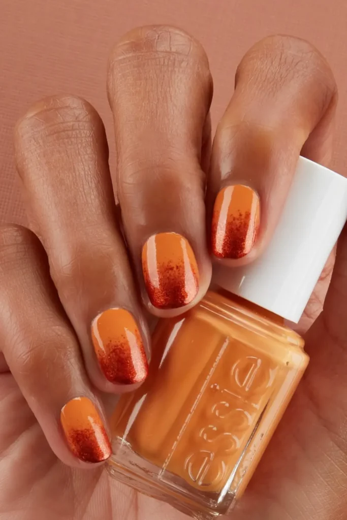 Long coffin nails with orange and nude ombre pumpkin spice-inspired design.