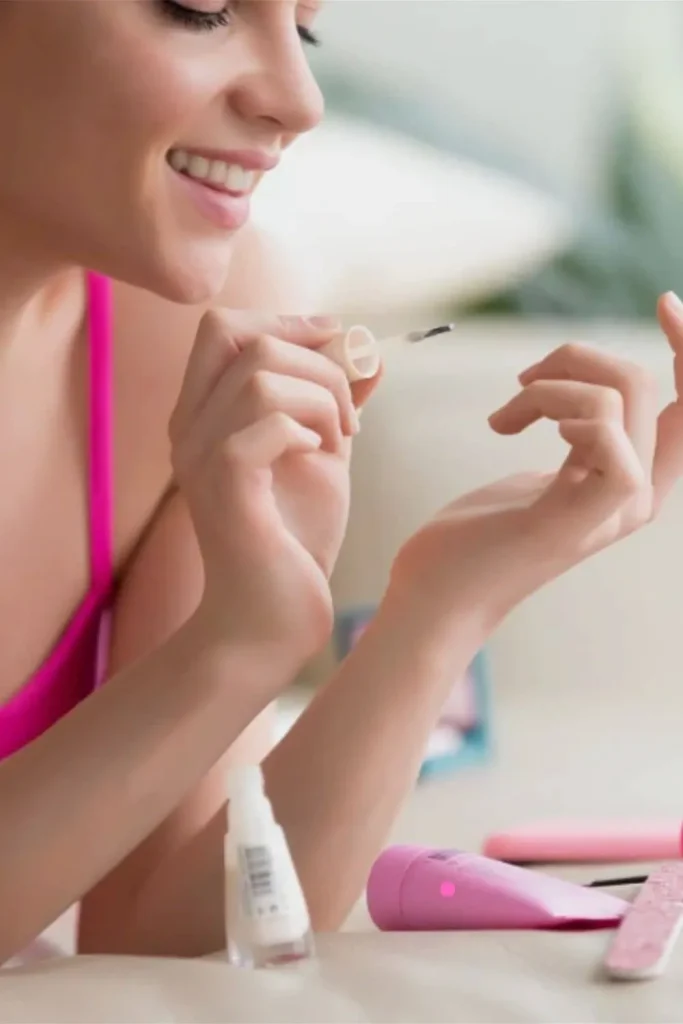 Gentle Cuticle Care Guide showing a smiling woman applying a base coat to healthy, well-maintained nails.