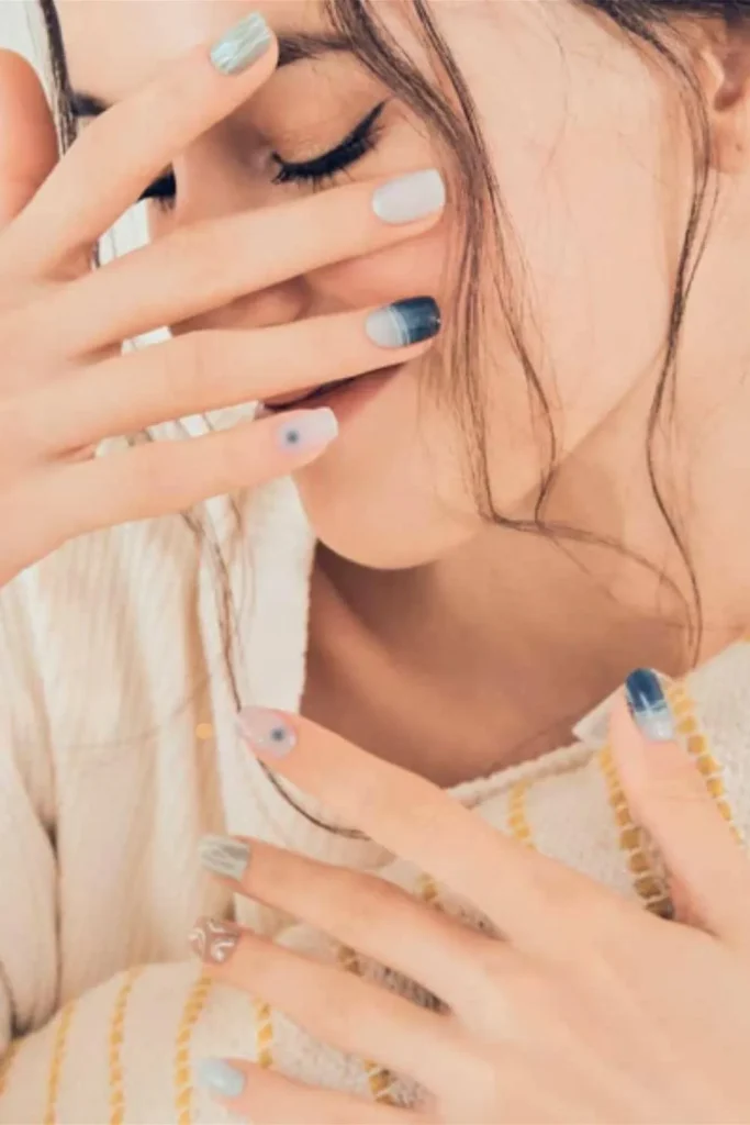 Gentle Cuticle Care Guide prep work showcasing healthy skin and a creative blue and grey nail art design.